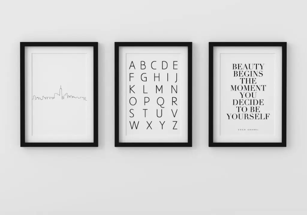 Set of three minimalist black and white wall art prints in frame on wall